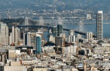 In this view of San Francisco, we see the TransAmerica Pyramid in the upper-left corner, the dome of City Hall is to the left, slightly below center, the tower of the Ferry Building is seen upper right of center and the United States Mint is seen in the center of the picture's foreground.  Photographed using a Canon SX40 HS camera.