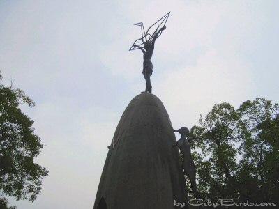 Atop the Children's Peace Monument is a girl holding a folded paper crane